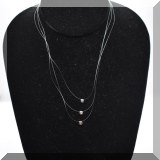 J034. 3 18K white gold bezel-set diamonds on clear line. - $165